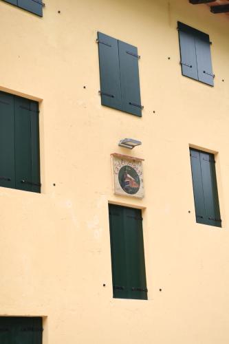 a clock on the side of a building with windows at Ca dei Ciossi in Concordia Sagittaria