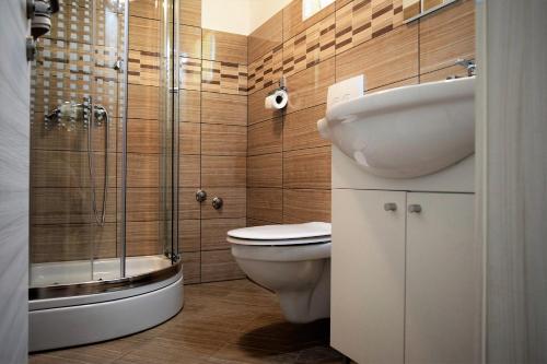 een badkamer met een wastafel, een toilet en een douche bij Apartments Kampor in Rab