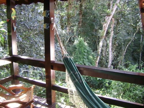 a hammock on the porch of a tree house at Chalé charmoso e aconchegante em Visconde de Maua in Visconde De Maua