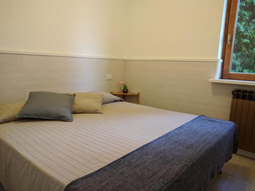 1 dormitorio con cama con almohada y ventana en Gina's Apartment, en Riva di Solto