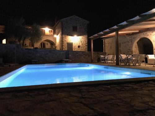 a large blue swimming pool in a yard at night at La Rimbecca Greve in Chianti in Greve in Chianti