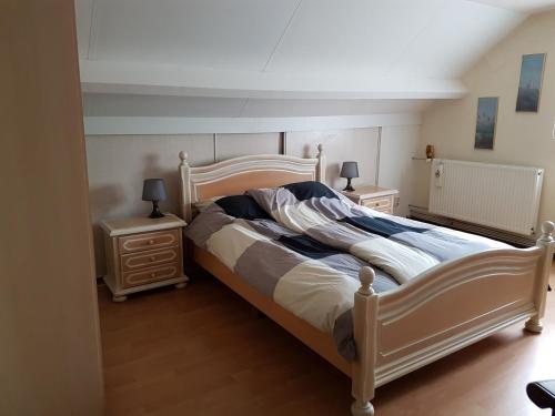 a bedroom with a large bed and two night stands at De Boerebeemd in Lieshout