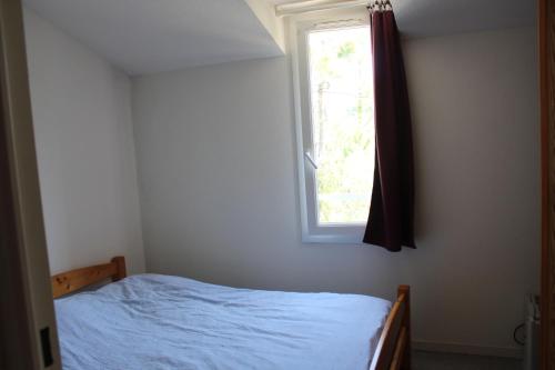 une chambre avec un lit et une fenêtre dans l'établissement Maison Saint Hilaire de Riez, 300m de la plage, à Saint-Hilaire-de-Riez