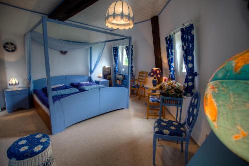 a bedroom with a blue bed and a table and chairs at Dom Mazurski Wiatrak in Giżycko
