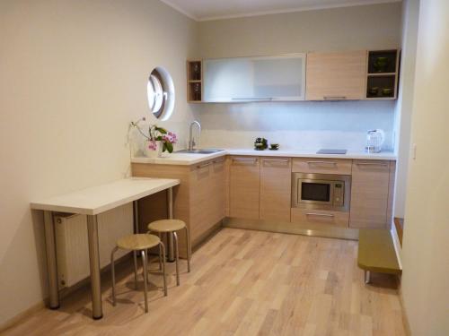 a small kitchen with a table and stools at Viesu nams "Svīre-10" in Ventspils