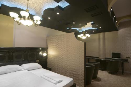 a bedroom with a bed with a black headboard and lights at Hotel Ženeva Lux in Kragujevac