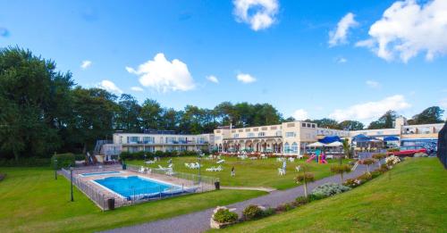 a resort with a swimming pool in a park at Langstone Cliff Hotel in Dawlish
