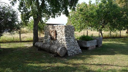 a stone wall in a field with a tree at Casa Vacanze Feudi 1165 in Borgo Vodice