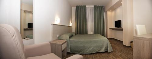 a room with a bed and a couch and a television at B&b Amiata in Arcidosso