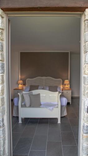 a white bed in a room with two lamps at Agriturismo Treterre in Pianello Del Lario