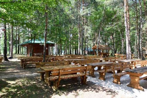a group of wooden benches in a park with trees at Tarcin Forest Resort & Spa Sarajevo - MGallery Collection in Tarčin