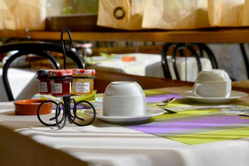 a table with a table cloth with glasses on it at Logis Lyon Est Porte de l'Ain in Saint-Maurice-de-Beynost