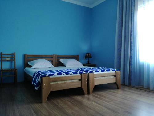 1 dormitorio con 1 cama con pared azul en Shekvetili+ en Shekhvetili