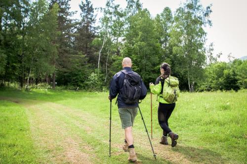 a man and a woman walking down a dirt road at Tarcin Forest Resort & Spa Sarajevo - MGallery Collection in Tarčin