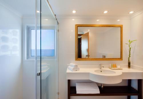 a bathroom with a sink and a mirror and a shower at Orchid Tel Aviv in Tel Aviv