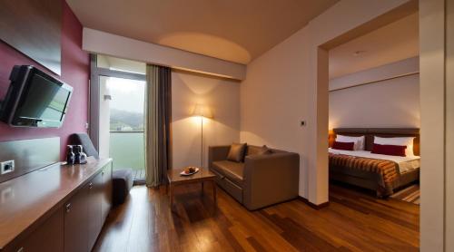 a hotel room with a bed and a chair and a television at Hotel Kaj in Marija Bistrica