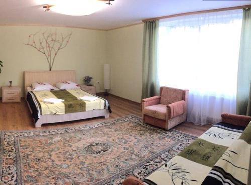 a bedroom with two beds and a chair and a rug at Садиба у Брусків in Mizhhirʼʼya