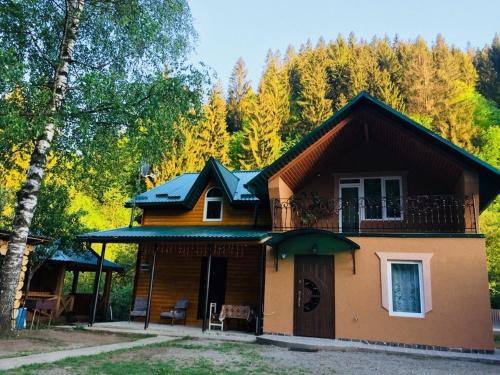a house with a balcony on top of it at Садиба у Брусків in Mizhhirʼʼya