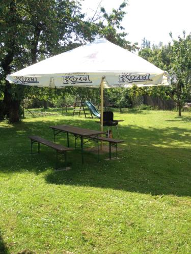 a picnic table under an umbrella in a park at Klub U Námořníka in Dvůr Králové nad Labem