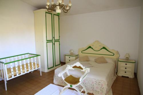 a bedroom with a bed and a crib and a crib at Addisora Appartamenti in Cala Liberotto