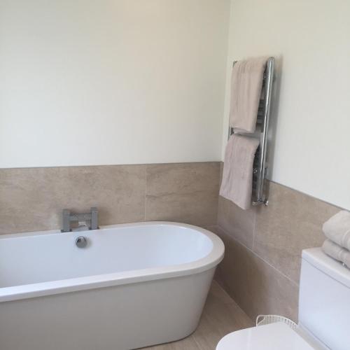 a bathroom with a white tub and a toilet at Luxury house with Sea views in Bangor