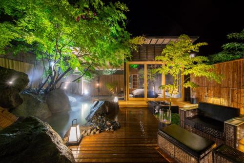 a house with a pond in the backyard at night at Hikyou Shirakawagensen Sansou Takefue in Minamioguni