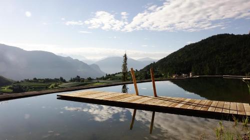a wooden dock sitting on top of a body of water at Tirolerhof Tisens in Tesimo