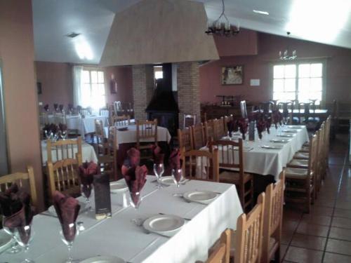 a dining room with white tables and chairs with wine glasses at L'Ermita Casa Ripo in Vall dʼAlba