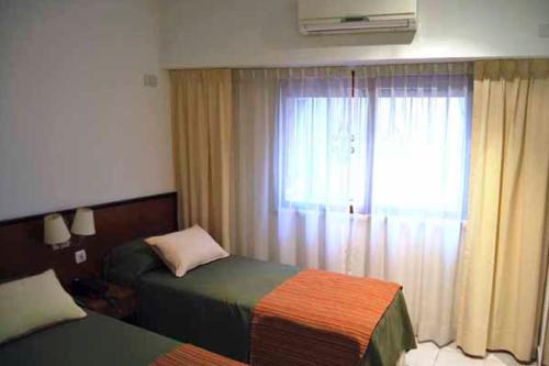 um quarto de hotel com duas camas e uma janela em Sojo Apart Hotel em Buenos Aires