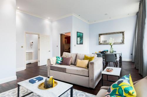 a living room with a couch and a table at Lancaster Gate Hyde Park by London Hotel Collection in London