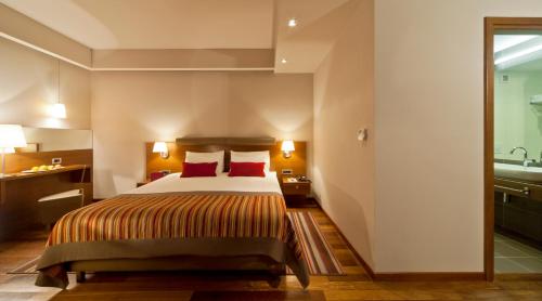a hotel room with a bed with red pillows at Hotel Kaj in Marija Bistrica
