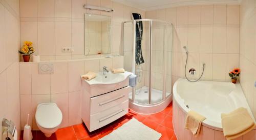 ein Badezimmer mit einem Waschbecken, einer Badewanne und einem WC in der Unterkunft Pension Greti in Schönau am Königssee