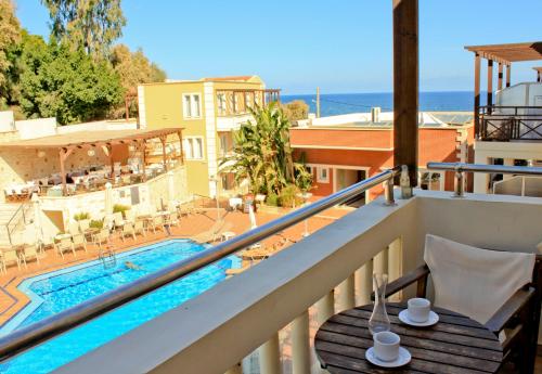 a balcony with a view of a swimming pool at Porto Kalamaki Hotel in Kalamaki Chanion