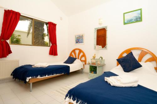 NazaretにあるCasa Luluのベッドルーム1室(ベッド2台、窓付)