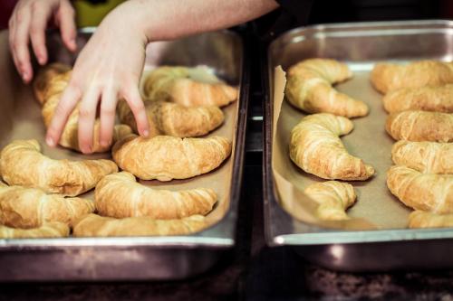 a person reaching for a bunch of croissants in trays at BLUME Baden Hotel & Restaurant in Baden