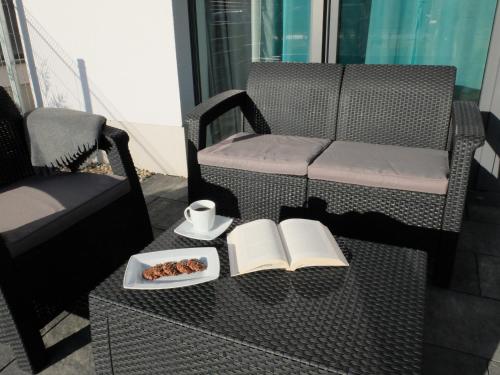 einen Tisch mit einem Buch und einer Tasse und einem Teller Essen in der Unterkunft Apartament 33BalticBlue in Pogorzelica