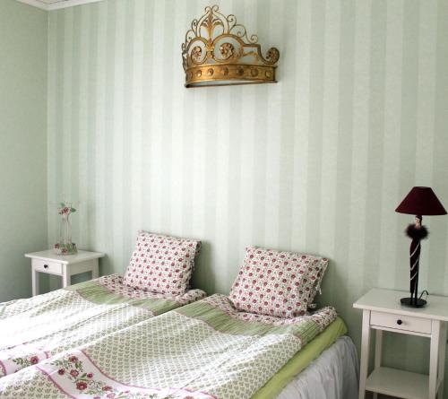 a bedroom with a bed with a crown on the wall at Eräjärven Eerola Guesthouse in Eräjärvi