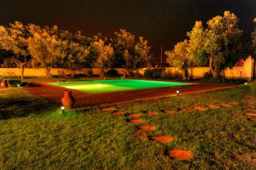 a pool in the middle of a yard at night at Hotel Rural Monte Da Rosada in Estremoz