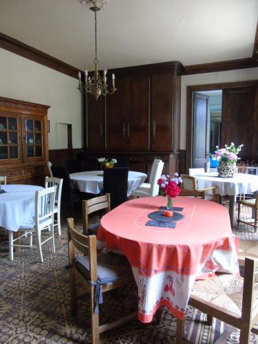 a dining room with a table with a red table cloth at Eco Logis de Chantegrolle in Champagne-Mouton