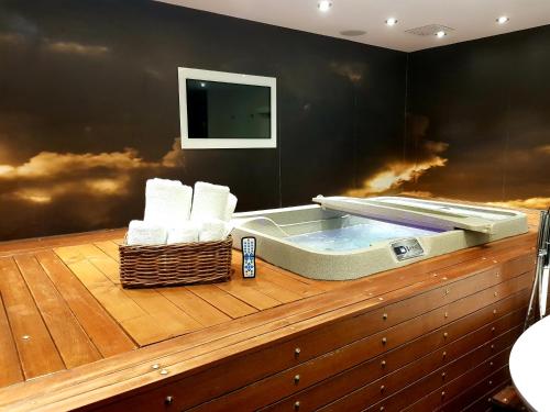 a jacuzzi tub with towels on a wooden deck at The Exhibitionist Hotel in London