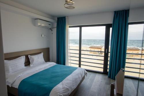 Schlafzimmer mit einem Bett und Meerblick in der Unterkunft Belleview Suites in Mamaia