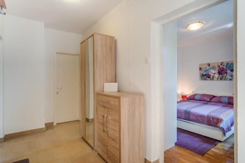 1 dormitorio con 1 cama y vestidor de madera con armario en Bandalo, en Mali Lošinj