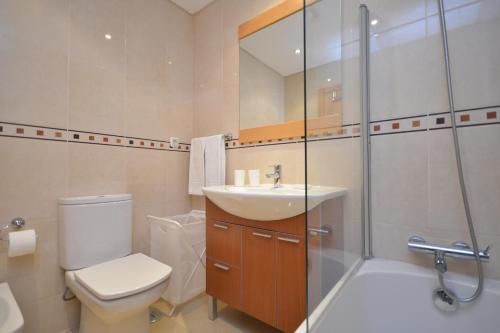 een badkamer met een toilet, een wastafel en een douche bij Millennium Golf Residences in Vilamoura