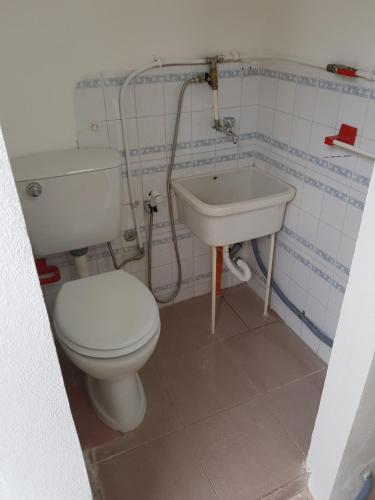 a bathroom with a toilet and a sink at DesyMar Inn in Fontane Bianche