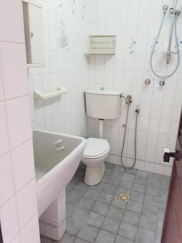 a bathroom with a toilet and a tub and a sink at DesyMar Inn in Fontane Bianche
