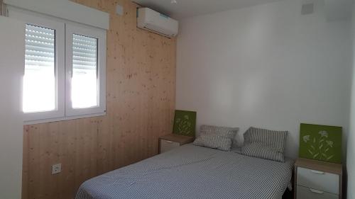 um quarto com 2 camas e uma janela em Acogedor apartamento en el barrio del Parlamento de Andalucía (Sevilla) em Sevilha