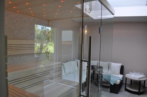 a bathroom with a glass shower with a table at Strandvilla Waldhaus in Boltenhagen
