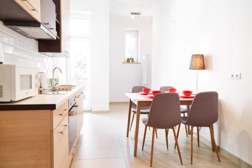 a kitchen with a table with chairs and a microwave at Modern Apartments in Krakow