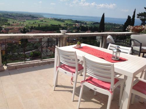 a white table and chairs on a balcony with a view at Villa Rossa in Cavaion Veronese