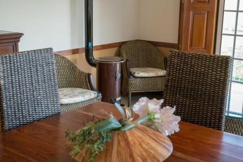 a wooden table with two chairs and a pumpkin on it at Quinta Sta Luzia Carrascal in Vila Flor